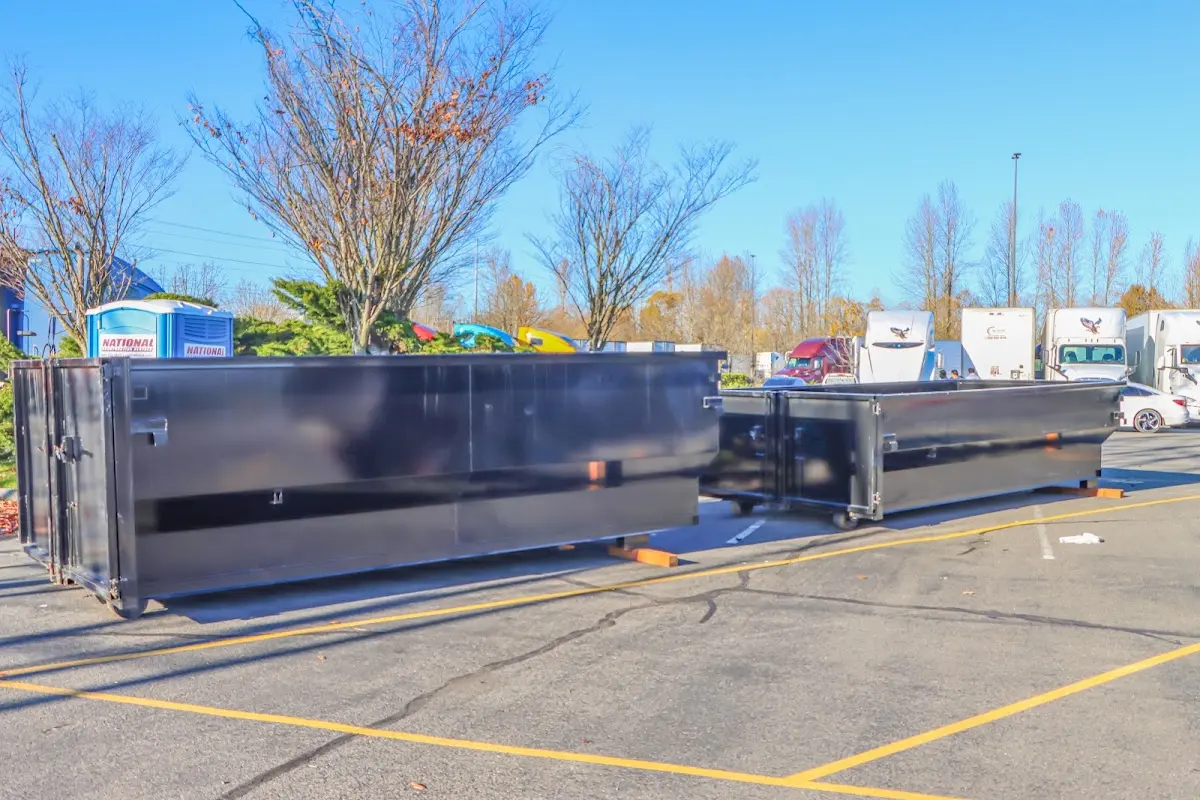 Professional dumpster rental service with roll-off container on residential driveway in East Lake